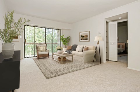 a living room with a couch and a table in front of a sliding glass door